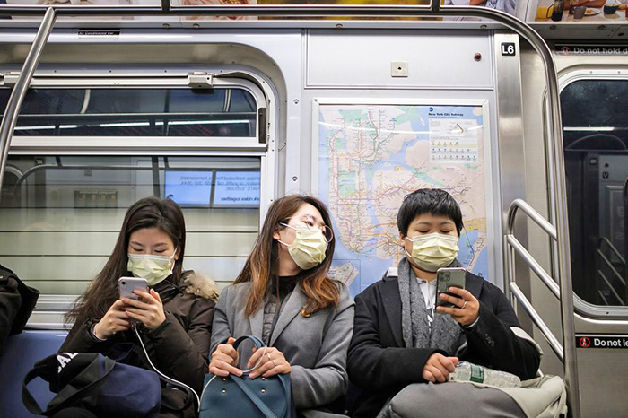 photo of 3 people on subway with face masks