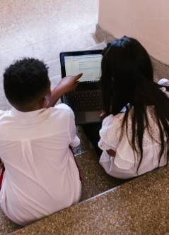 Photo of 2 students looking at a laptop
