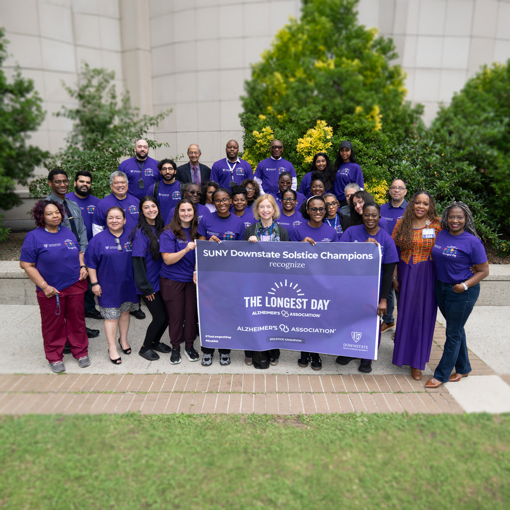 group photo of people standing holding a banner
