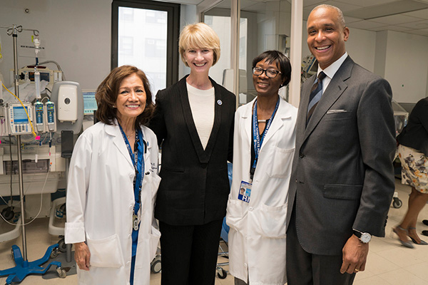 photo of 3 Trustees with Dr. Riley