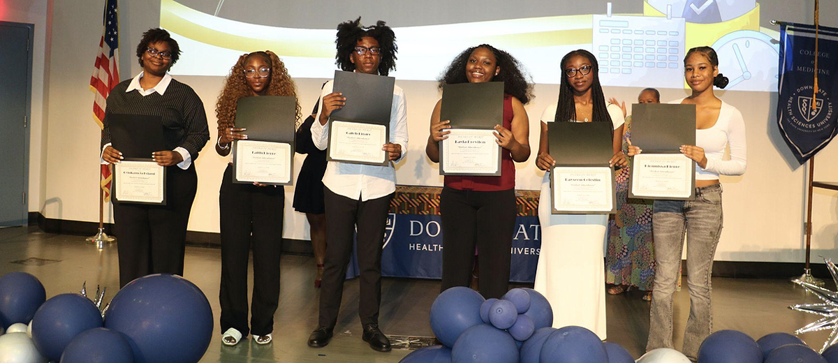group of young people holding certificates on a stage