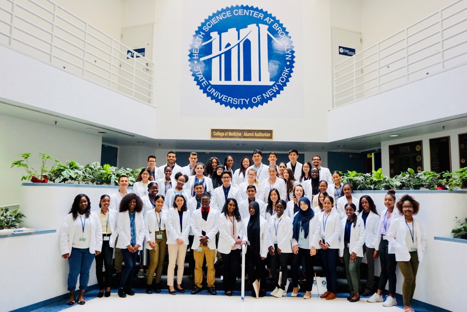 EHC students pose for group photo wearing white coats