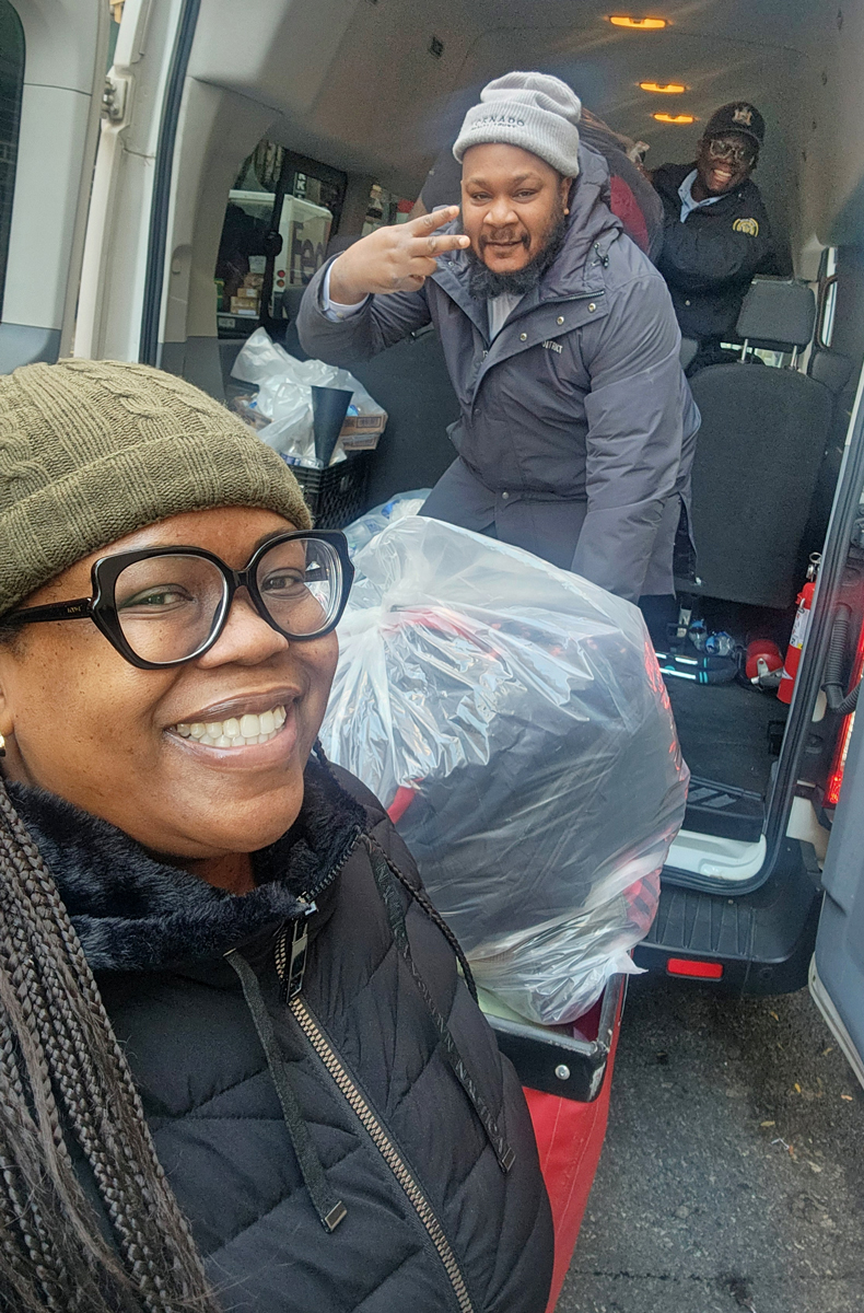 photo of three people unloading large plastic bags of coats