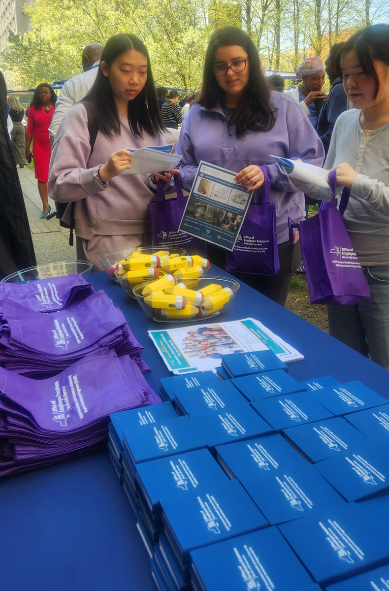 photo of two women standing by a table looking at free swag offerings