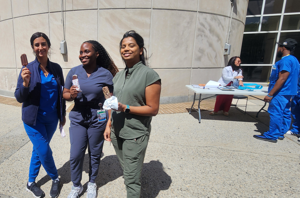 photo of three women standing outside holding icecream bars and smiling