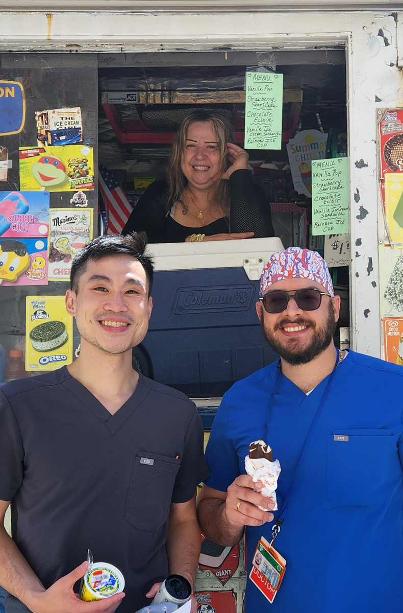 2 men standing in from of an icecream truck