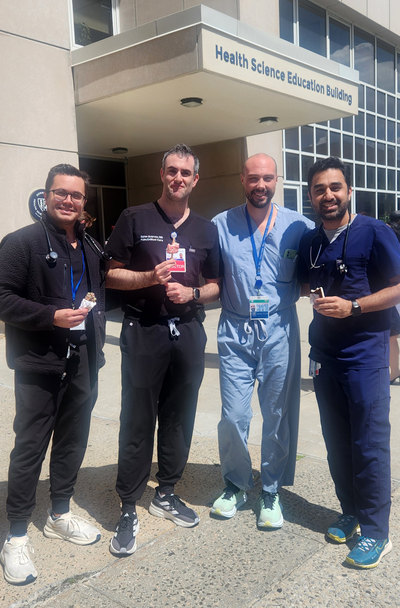 photo of four men standing outside holding icecream bars