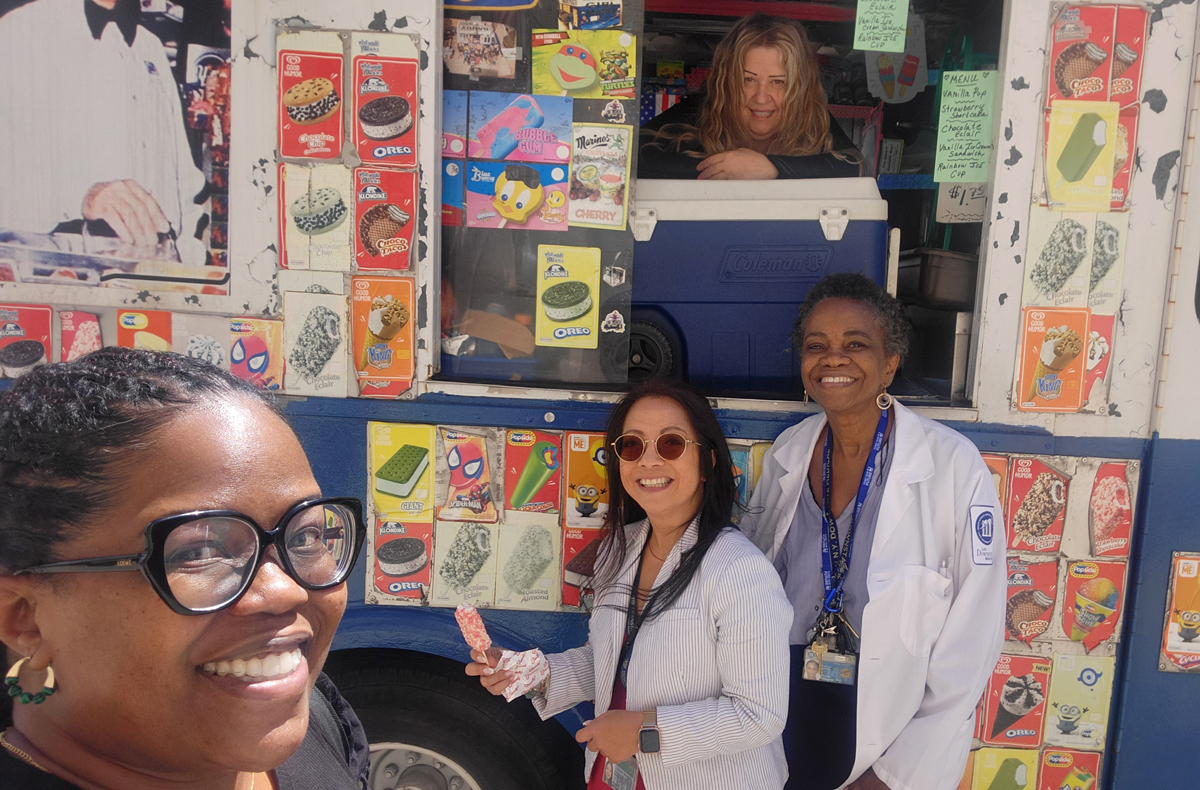 selfie photo of three women standing by the open window of an icecream truck with a woman leaning out