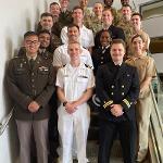 Sierrah Grigsby in a group photo on a staircase with other individuals in military dress
