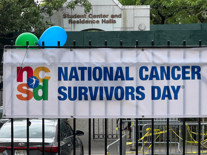 sign on fence reading National Cancer Survivors Day