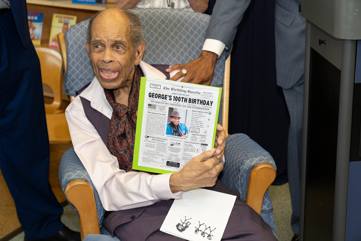 photo of elderly man holding up newspaper headline