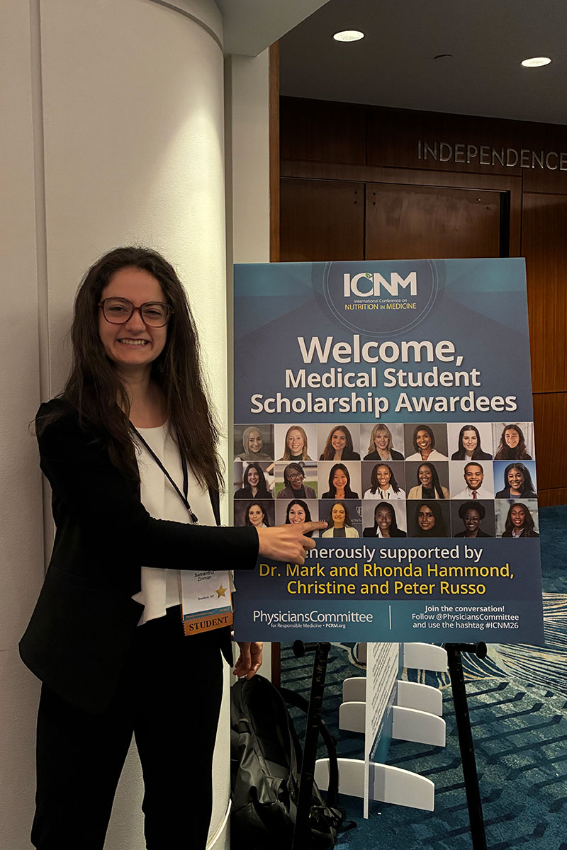 photo of Samantha Zinman in front of poster