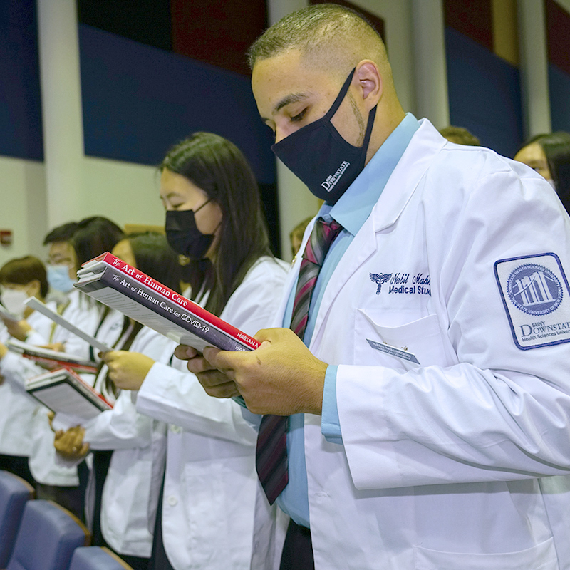 students reading at White Coat Ceremony