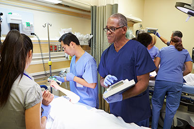 photo of doctor standing next to patient bed